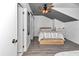 Bedroom with gray wood floors, a ceiling fan, neutral paint and a wooden bedframe at 12677 Se 53Rd Terrace Rd, Belleview, FL 34420