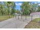 Gated driveway leads to a charming white farmhouse with fenced pasture, offering privacy and a picturesque setting at 12677 Se 53Rd Terrace Rd, Belleview, FL 34420