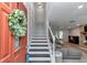 Welcoming entryway with a staircase, a stylish wreath on the red door, and a glimpse into the cozy living room at 12677 Se 53Rd Terrace Rd, Belleview, FL 34420
