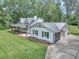 Exterior of home and detached garage with a metal roof and lovely landscaping at 12677 Se 53Rd Terrace Rd, Belleview, FL 34420