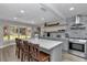 Modern kitchen featuring a large island with seating, gray cabinetry, stainless steel appliances, and stylish decor at 12677 Se 53Rd Terrace Rd, Belleview, FL 34420