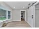 Bright living room featuring wood floors, a bay window, and a modern barn door at 12677 Se 53Rd Terrace Rd, Belleview, FL 34420