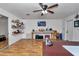 Open living area with wood floors, shelving, ceiling fan, and an entertainment center at 12677 Se 53Rd Terrace Rd, Belleview, FL 34420