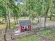 Red outbuilding structure in a wooded area with a fenced enclosure at 12677 Se 53Rd Terrace Rd, Belleview, FL 34420