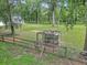 Outbuilding structure in a wooded area with a fenced enclosure at 12677 Se 53Rd Terrace Rd, Belleview, FL 34420