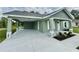 View of the front exterior with covered parking and well-manicured landscaping at 13319 Sw 106Th Pl, Dunnellon, FL 34432
