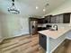 Modern kitchen with stainless steel appliances, dark cabinets, and quartz countertops, plus a large island at 13319 Sw 106Th Pl, Dunnellon, FL 34432