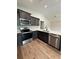 Stylish kitchen with stainless steel appliances, dark cabinets, and a breakfast bar overlooking an open living area at 13319 Sw 106Th Pl, Dunnellon, FL 34432