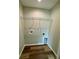 Compact laundry room with wood-look flooring and shelving for storage at 13319 Sw 106Th Pl, Dunnellon, FL 34432