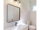 Modern bathroom with a white vanity, a large mirror, a sleek faucet, and tiled toilet area at 15215 Sw 43Rd Ct, Ocala, FL 34473