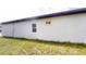 A clean, white-walled home exterior, featuring two windows and a green lawn at 15215 Sw 43Rd Ct, Ocala, FL 34473