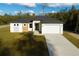 Modern home featuring a two-car garage, contemporary design, landscaped front yard, and neutral color palette at 15215 Sw 43Rd Ct, Ocala, FL 34473