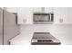 Stainless steel microwave and electric range, white cabinets, and white subway tile backsplash at 15215 Sw 43Rd Ct, Ocala, FL 34473