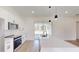 Bright kitchen features white cabinetry, stainless steel appliances, and a large island with modern pendant lighting at 15215 Sw 43Rd Ct, Ocala, FL 34473