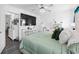 Airy bedroom with ceiling fan, decorative dresser, and a large mounted television at 15324 Sw 40Th Place Rd, Ocala, FL 34481