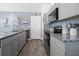 Modern kitchen features granite countertops, stainless steel appliances, and stylish gray cabinetry at 15324 Sw 40Th Place Rd, Ocala, FL 34481
