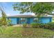 Charming single-story home featuring a blue exterior, mature trees, and a cozy front porch area at 17128 Se 140Th Ave, Weirsdale, FL 32195
