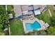 Aerial view of backyard with pool, patio, and lush landscaping surrounding blue home at 2922 Cocovia Way, Leesburg, FL 34748