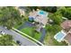 Aerial view of a blue house with a long driveway, pool, and lush green landscaping at 2922 Cocovia Way, Leesburg, FL 34748