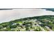Aerial showcases waterfront community with manicured lawns and tree-lined streets at 2922 Cocovia Way, Leesburg, FL 34748