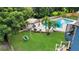 Lush backyard with a pool, patio, and a charming pergola with a swing set at 2922 Cocovia Way, Leesburg, FL 34748