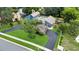 Aerial view of a modern blue home with pool, large driveway, mature trees and lush landscaping at 2922 Cocovia Way, Leesburg, FL 34748