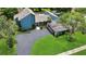 Aerial view of a modern blue home with a large driveway, a pool and lush landscaping at 2922 Cocovia Way, Leesburg, FL 34748