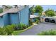 Charming blue home with mature landscaping and a convenient covered parking area at 2922 Cocovia Way, Leesburg, FL 34748