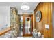 Foyer features stone accents, wood paneled wall, modern lighting, and a unique front door at 2922 Cocovia Way, Leesburg, FL 34748