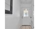 Bright hallway featuring a decorative glass front door and an elegant mirror at 2922 Cocovia Way, Leesburg, FL 34748