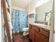 Bathroom featuring a wood-look vanity, decorative shower curtain, and ladder towel rack at 3021 Beard Rd, The Villages, FL 32163