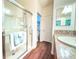 Bathroom featuring a shower with glass door, wood-look floors, and white countertops at 3021 Beard Rd, The Villages, FL 32163