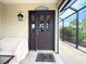 Inviting front door with sidelights, and a covered porch area with seating and screened windows at 3021 Beard Rd, The Villages, FL 32163