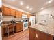 Modern kitchen featuring wood cabinets, an island, and stainless steel appliances at 3021 Beard Rd, The Villages, FL 32163