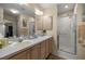 A bathroom featuring double sinks, a shower, and plenty of storage space at 3024 Burbank Ln, The Villages, FL 32162