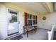 Covered porch with seating, decorative shutters and front door at 3024 Burbank Ln, The Villages, FL 32162