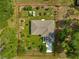Aerial view of home showcasing its well-defined property lines, lush greenery, and meticulously landscaped garden area at 3445 Se 139Th Ln, Summerfield, FL 34491