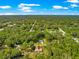 Scenic aerial image displaying lush tree coverage, roads, and an arrow pointing to the property's location in nature at 3445 Se 139Th Ln, Summerfield, FL 34491