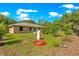 Spacious backyard featuring green grass, trees, and exterior utilities equipment at 3445 Se 139Th Ln, Summerfield, FL 34491
