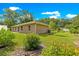 Beautiful backyard with a lush green lawn, trees and planting beds at 3445 Se 139Th Ln, Summerfield, FL 34491
