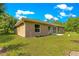 Expansive backyard featuring lush green lawn, neutral-toned exterior, and mature trees at 3445 Se 139Th Ln, Summerfield, FL 34491