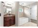 Detailed bathroom with tiled shower and flooring, dark cabinets, and a soaking tub at 3445 Se 139Th Ln, Summerfield, FL 34491