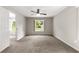 Neutral bedroom with carpet flooring, ceiling fan, and view of outdoor landscape at 3445 Se 139Th Ln, Summerfield, FL 34491