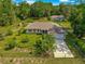 Aerial view of a charming single-story home with a well-manicured lawn, mature trees, and fenced yard at 3445 Se 139Th Ln, Summerfield, FL 34491