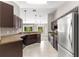 An open kitchen with stainless steel appliances, tan granite countertops, and tiled flooring at 3445 Se 139Th Ln, Summerfield, FL 34491