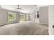 Spacious living room featuring neutral paint, plush carpeting and a sliding glass door at 3445 Se 139Th Ln, Summerfield, FL 34491