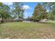 Well-maintained backyard with ample green space, screened lanai, and mature trees at 4085 Ne 17Th Ave, Ocala, FL 34479