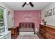 Adorable Bedroom with pink accent wall, wood-look tile flooring, and plenty of storage at 4085 Ne 17Th Ave, Ocala, FL 34479