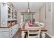 Elegant dining area with a rustic wooden table, white chairs, and ample natural light from bay windows at 4085 Ne 17Th Ave, Ocala, FL 34479