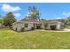 Landscaped home with a well-maintained lawn, mature trees, and an attached two-car garage at 4085 Ne 17Th Ave, Ocala, FL 34479